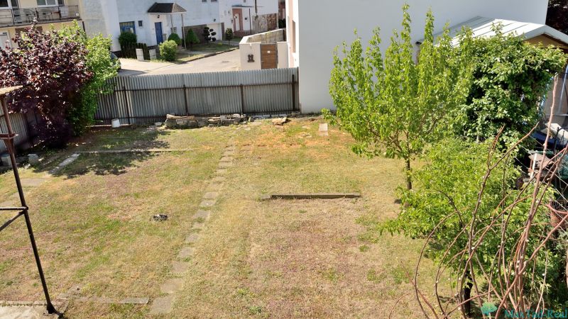 A garden behind a family house, with a lawn and trees on Nabr. J. M. Hurbana Street in Michalovce.