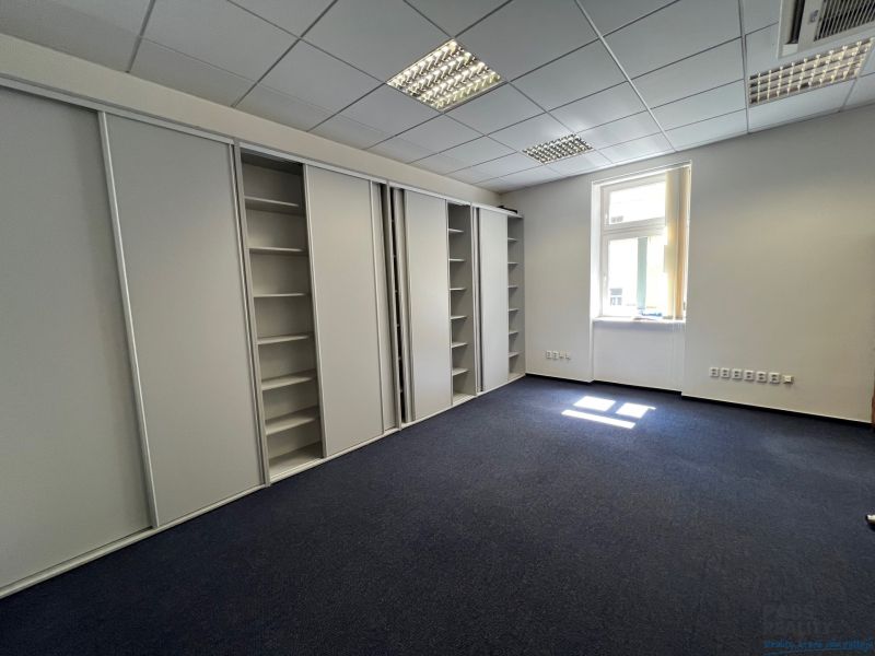 Offices with dark carpet, built-in wardrobes, and a window.