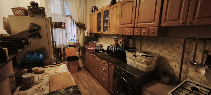 A kitchen in a 2-room apartment with wooden cabinets and appliances.