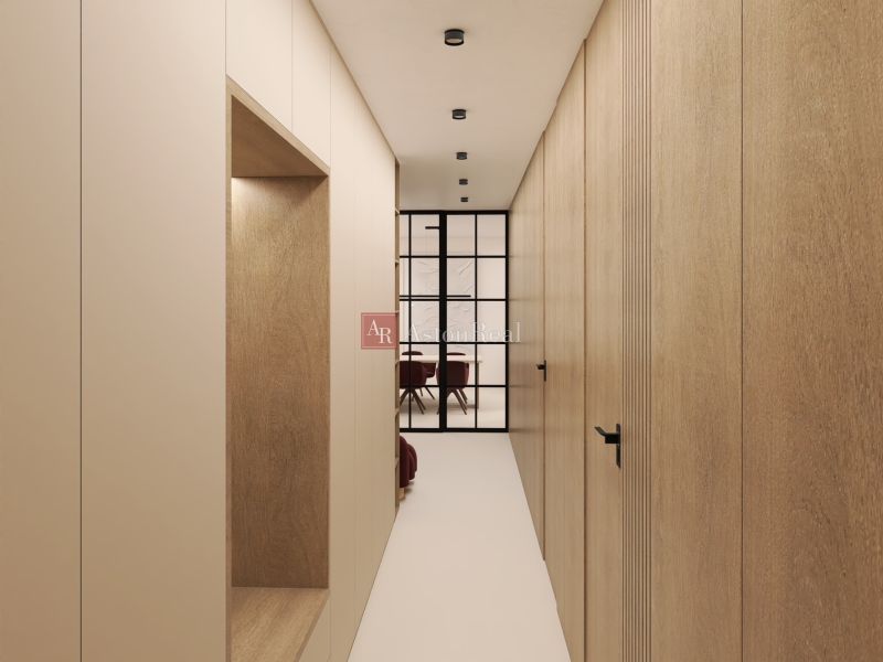 A narrow hallway with wooden decor and a glass partition in a two-room apartment.