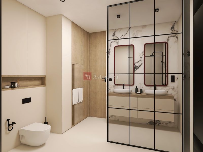 A bathroom in a 2-room apartment with double sinks, wood-patterned flooring, and a mirror.