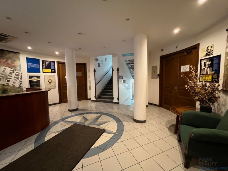 Office interior with staircase, reception, and patterned tile flooring.