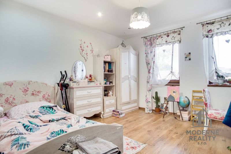 Children's room in a family house with a wooden decor floor and floral furniture.
