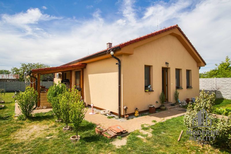 A family house in Andovce with a nicely landscaped garden and a brick walkway.