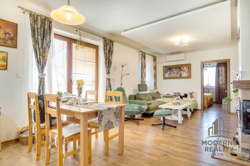 Dining room and living room with wood-patterned flooring in a family house.