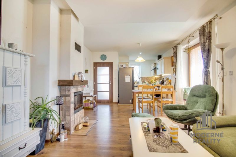 Living room with a fireplace and kitchen, family house, floor with wooden decor.