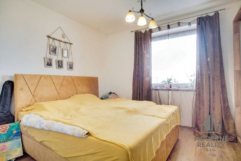 Bedroom in a family house with a bed and brown curtains.