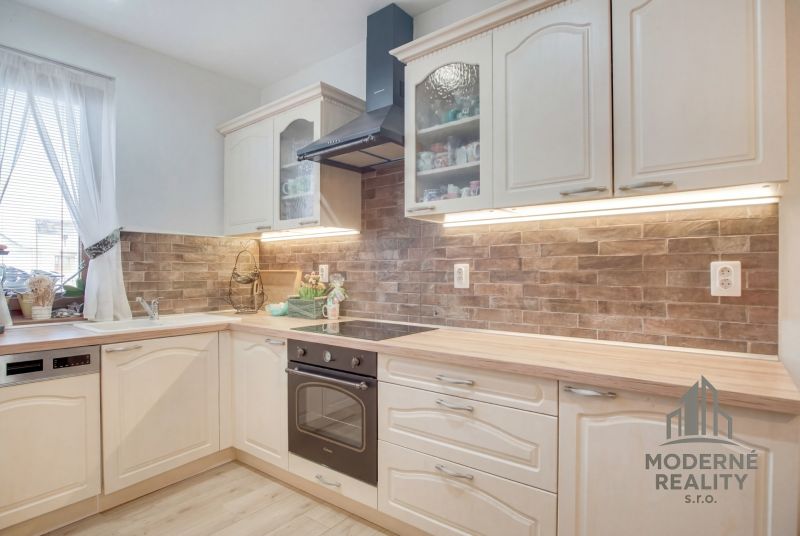 A kitchen in a family house with wooden decor and brick cladding on the cabinets.