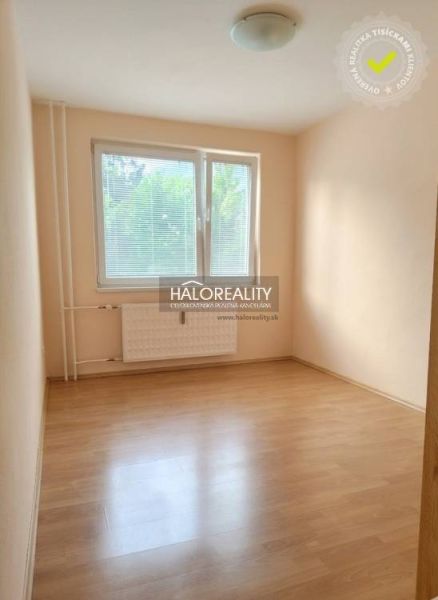 A room in a 3-room apartment with a wood-patterned floor and a large window.