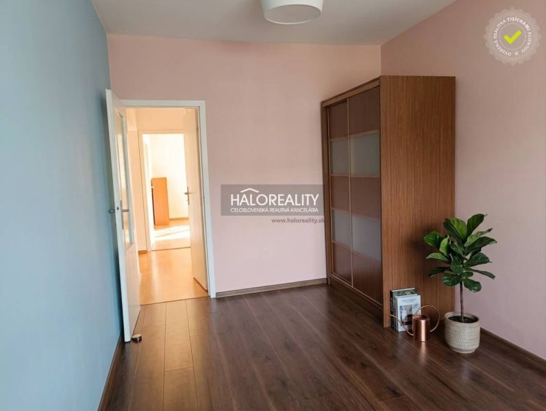 A room in a 3-room apartment with a wooden decor floor and a built-in wardrobe.