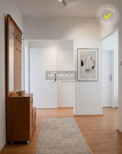 A hallway in a 3-room apartment with a wooden decor floor and modern furniture.