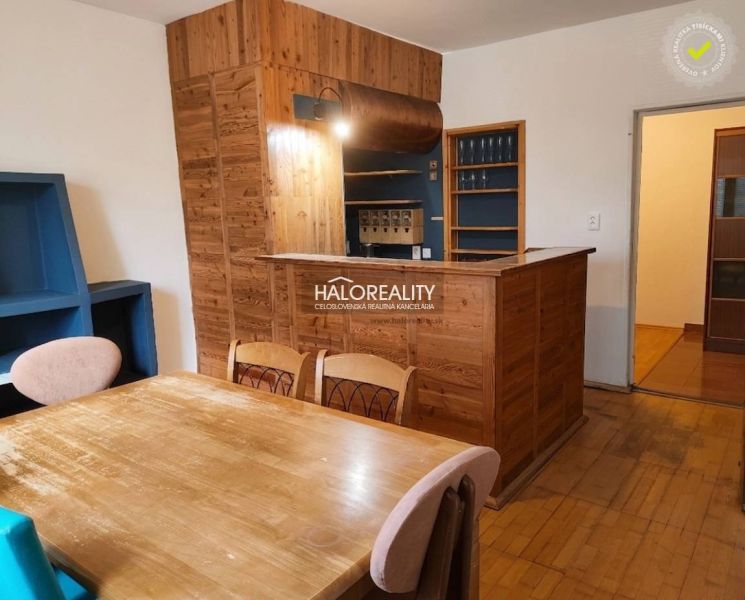 Dining room in a 3-room apartment with a wood-patterned floor and a wooden bar.