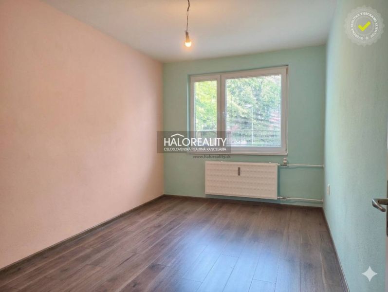 A room in a 3-room apartment with colored walls and a floor with a wooden decor.