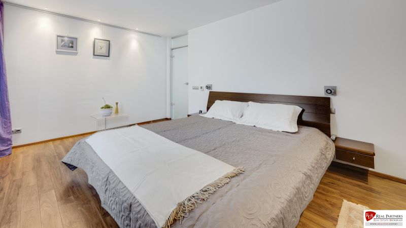 A bedroom in a 3-room apartment with a comfortable bed and a floor with a wooden decor.