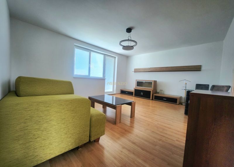 Living room with a sofa, table, and wooden decor flooring in a 3-room apartment.