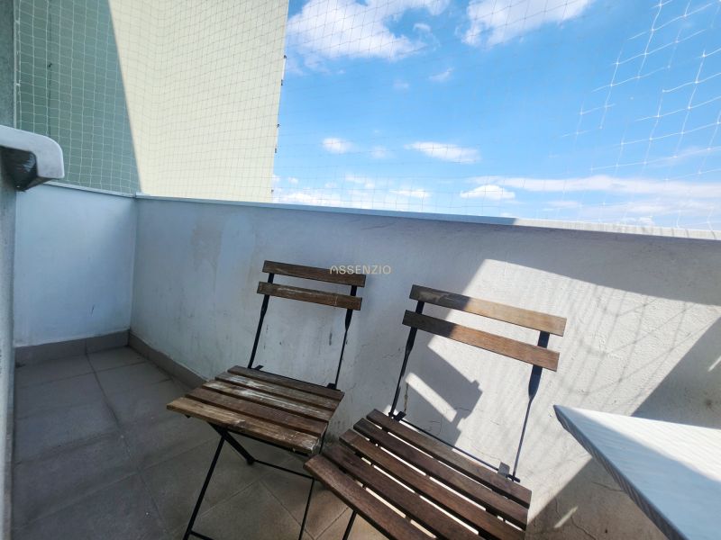 Balcony of a 3-room apartment with two wooden chairs, blue sky, and a protective net.