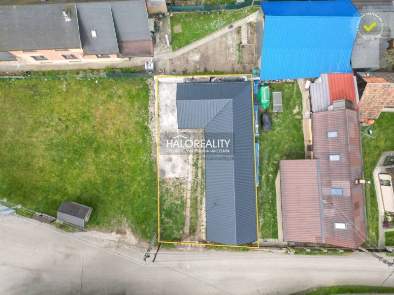 Aerial view of a family house in Stupno surrounded by a grassy plot and neighboring buildings.
