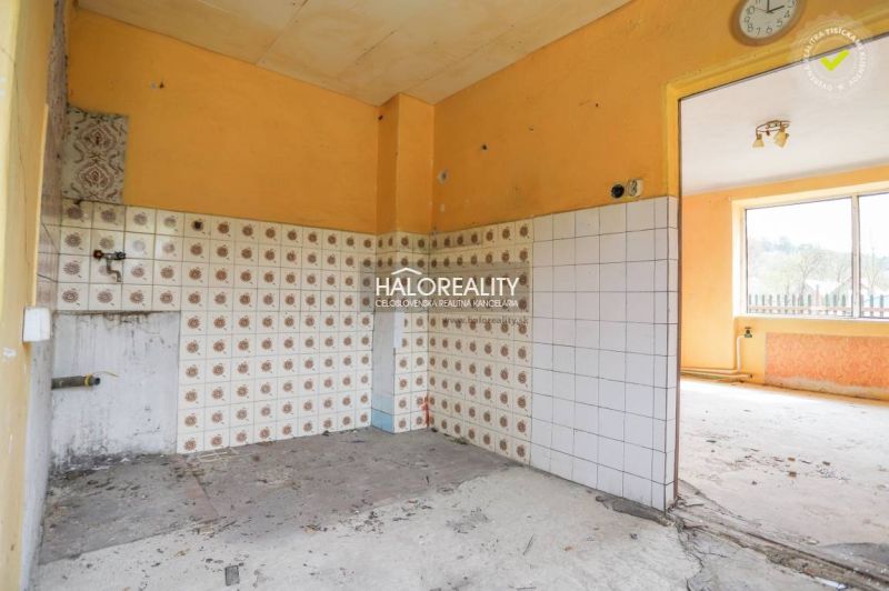 A kitchen with orange walls and patterned tiles in a family house.