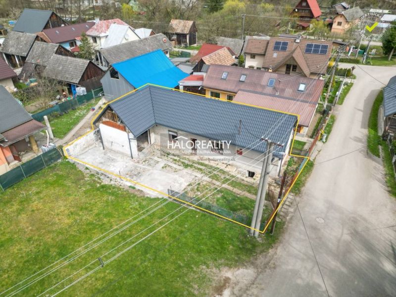 A family house in Stupno with a low blue roof profile, surrounded by neighboring buildings.