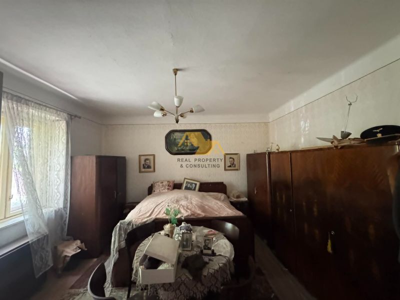 A bedroom in a family house with a bed, wardrobes, and curtains.