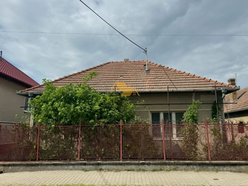 A family house in Bánov on Bánov Street with a brick roof and fence.