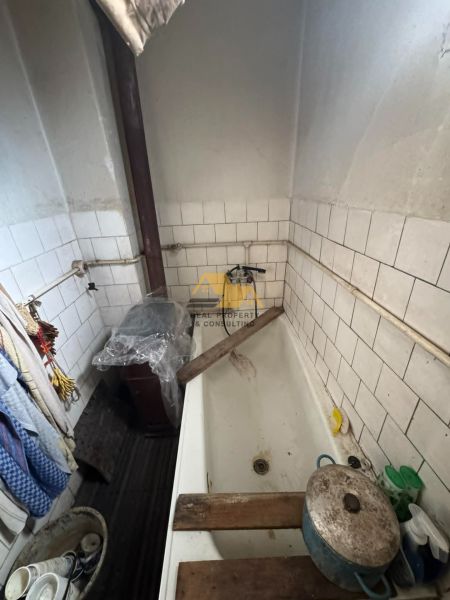 A small bathroom in a family house with white tiles and a bathtub.