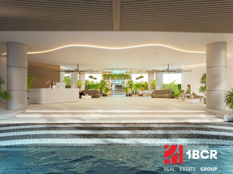 Interior of residential development with a reception and relaxation area, decorated with greenery and seating.
