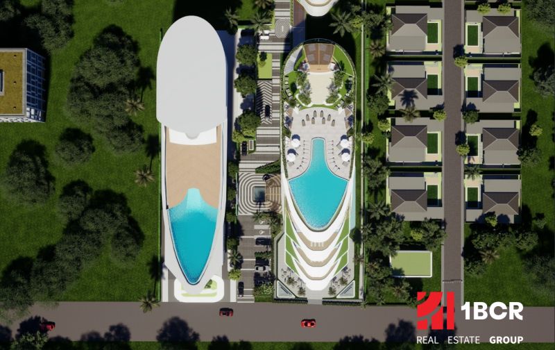 Aerial view of apartment construction in Phuket with a pool and villas.