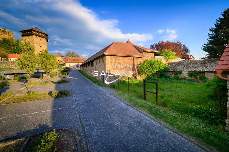 A stone pathway running alongside a historic building in the Grounds - commercial in Fiľakovo.