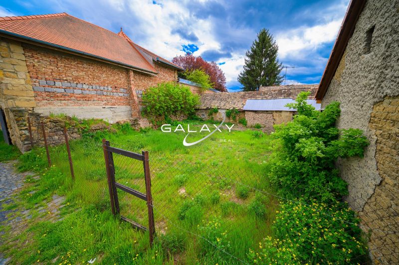 Lands - commercial in Fiľakovo, enclosed area with grass and stone buildings.