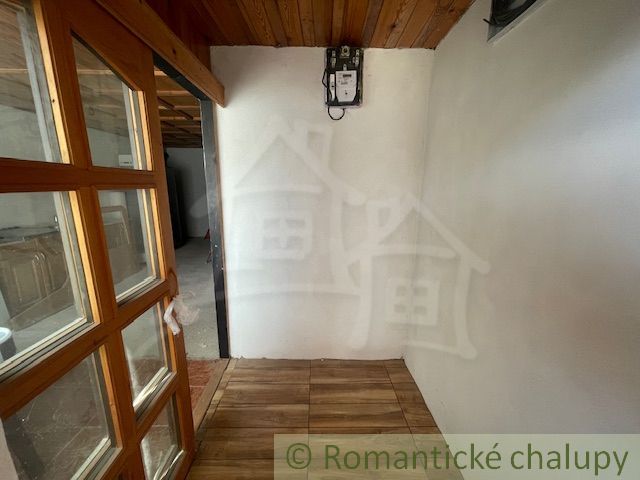 Interior with a wooden ceiling, doors with glass, and a floor with a wooden decor in a family house.