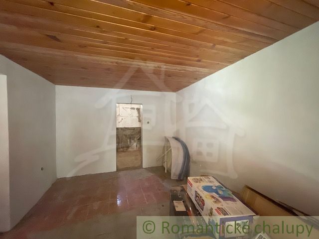 The interior of a family house with a wooden ceiling and tiles.