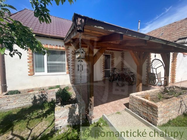 A family house in Palárikovo with a shelter, a swing, and bicycles in the yard.