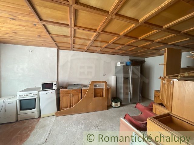 Kitchen space in a family house with a wooden ceiling and appliances.
