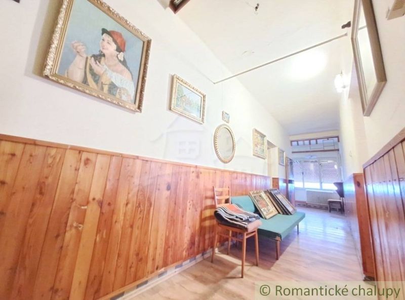 Hallway of a family house with wooden paneling, decorations, and flooring with a wooden design.