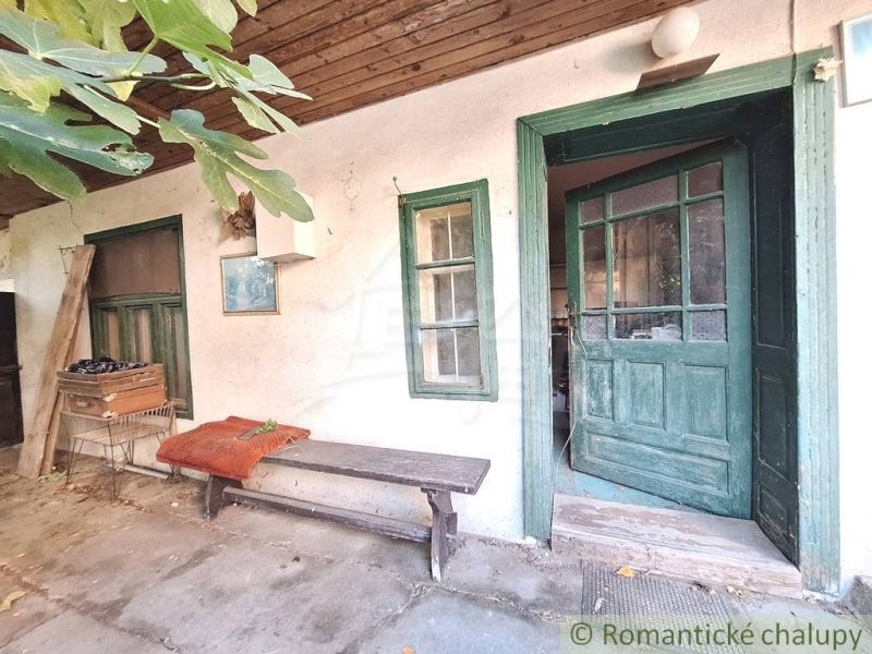 Old wooden door and a bench in the yard of a family house in Gbelce.