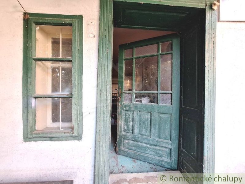Green wooden door and window on an old family house in Gbelce.
