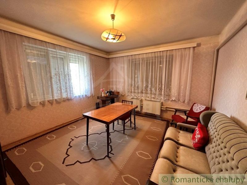 Living room with carpet decor, vintage furniture, and subtle lighting in a family house.