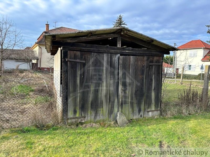 A wooden shelter with a fence in the garden of a family house in Kolárovo.