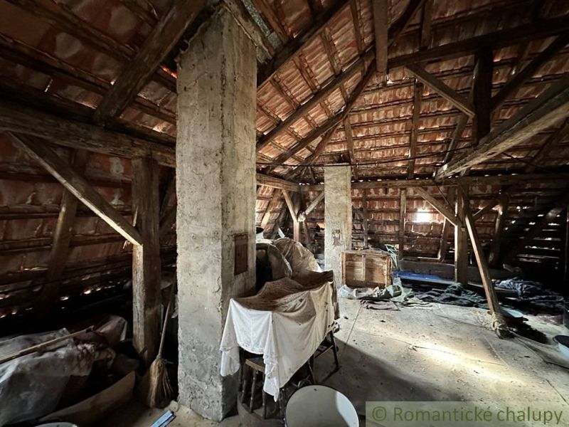 Attic in a family house with visible wooden beams and storage spaces.