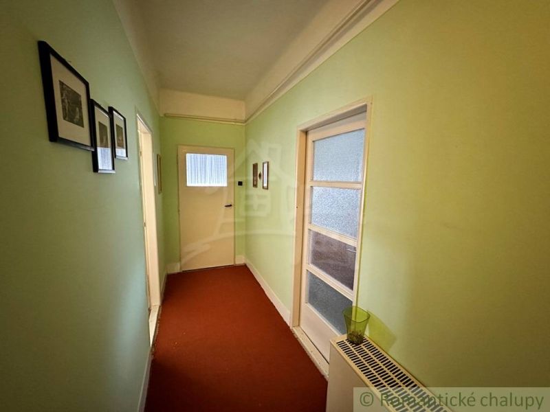 A hallway in a family house with painted walls and pictures on the walls.