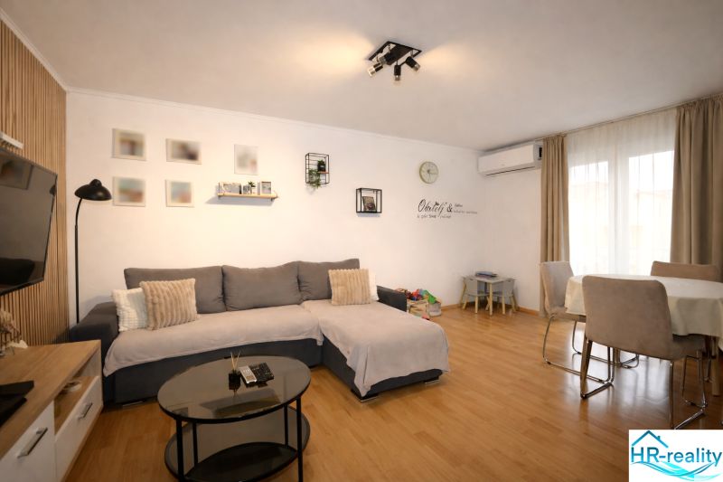 A comfortable living space in a holiday apartment with wood-patterned flooring and a dining table.