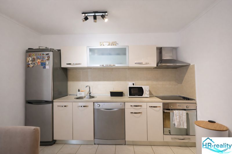 A kitchen unit in a holiday apartment with stainless steel appliances and a microwave.