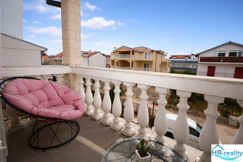 Balcony of a holiday apartment in Vodice, comfortable chair with a view of the buildings.