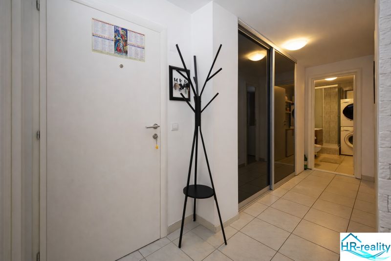 A hallway with a coat rack and a mirrored wardrobe in a holiday apartment.