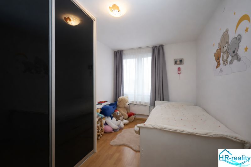 Children's room in a recreational apartment with toys, a bed, and a floor with a wooden decor.