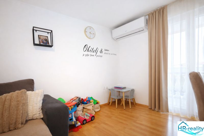 Interior of a holiday apartment with toys, a sofa, and a wooden decor floor.