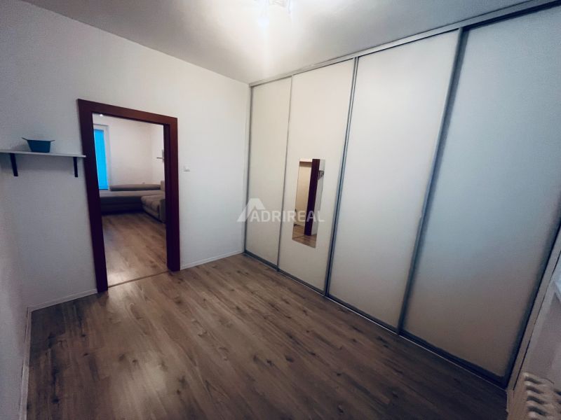 A hallway in a 3-room apartment with wardrobes and a floor with a wooden decor.