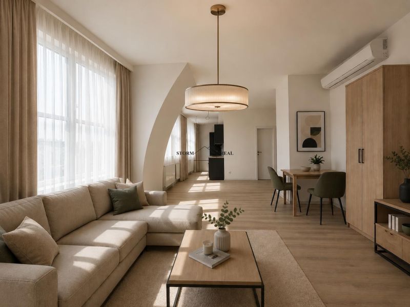 Living room with a sofa, table, and wooden decor flooring in a studio apartment.