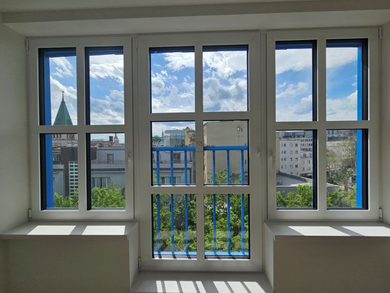 A view from a one-room apartment of the Bratislava skyline through large windows.